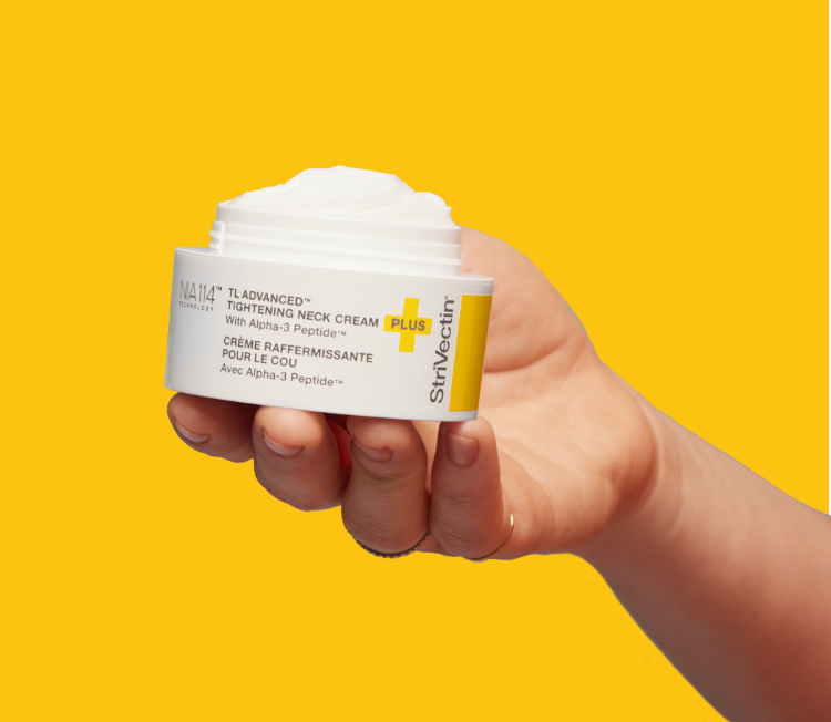 Hand holding open jar of TL Advanced Neck Cream